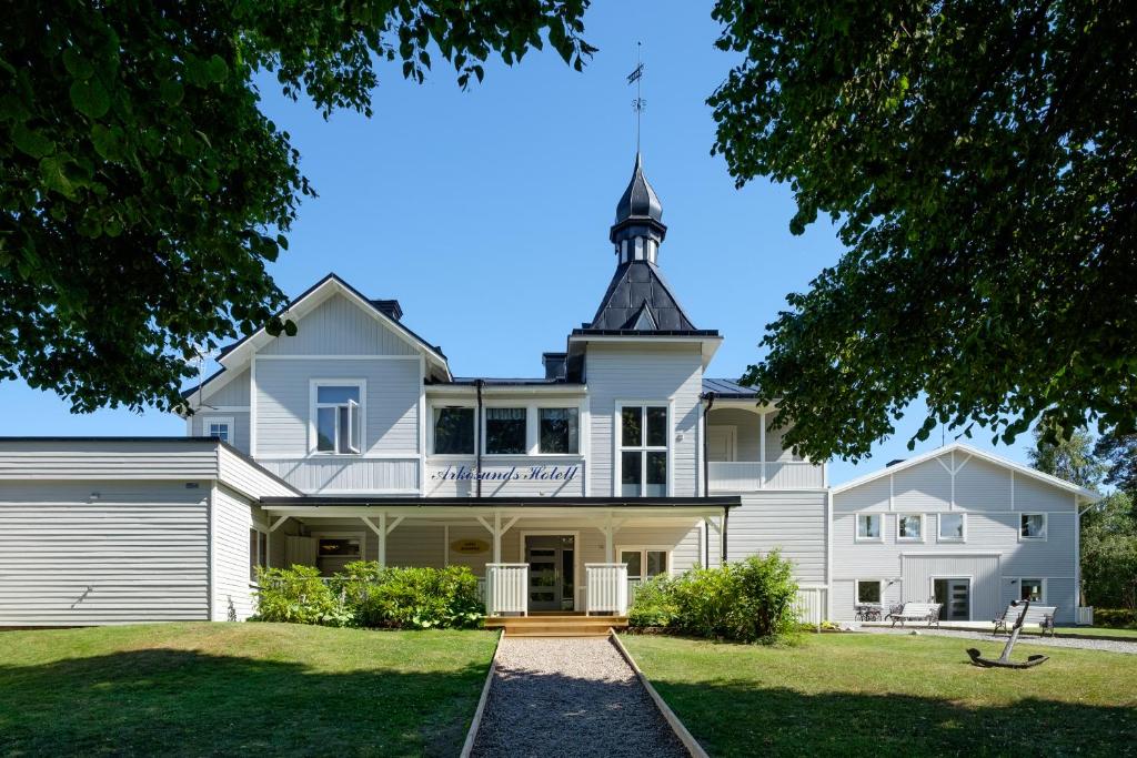 duży biały dom z wieżą na górze w obiekcie Arkösunds Hotell w mieście Arkösund