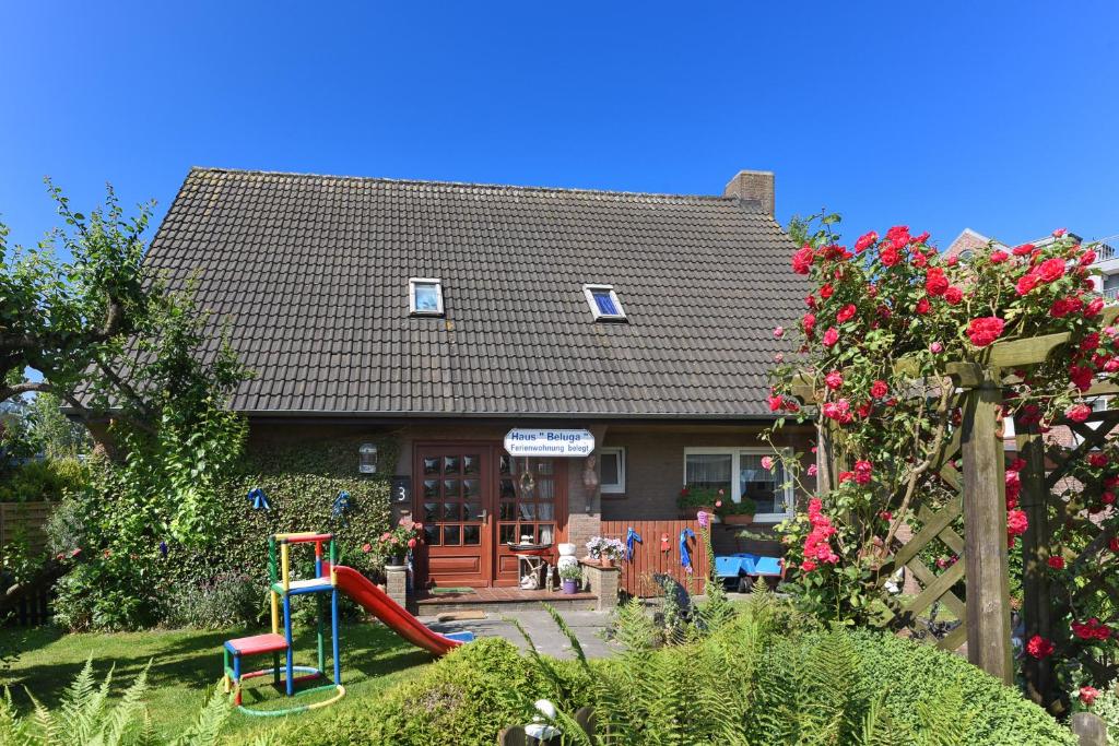 a house with a playground in front of it at Ferienwohnungen im Haus Beluga in Bensersiel