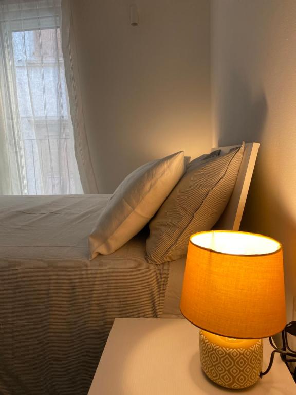 um quarto com uma cama com almofadas e um candeeiro em M8tto em Arco