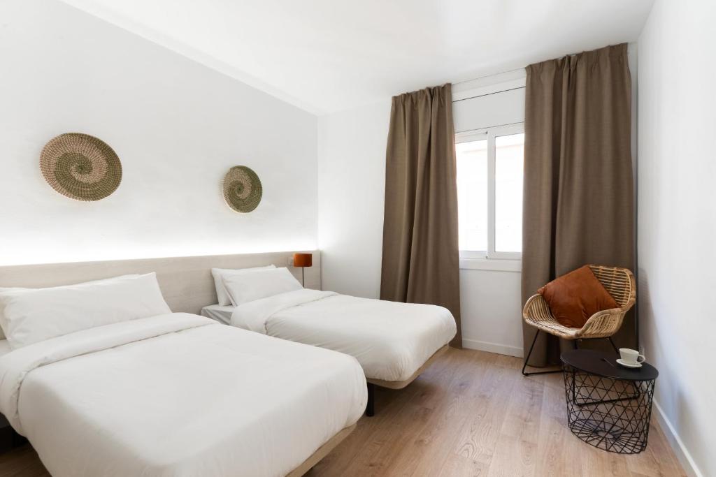 a hotel room with two beds and a window at Apartamentos Venecia in Lloret de Mar