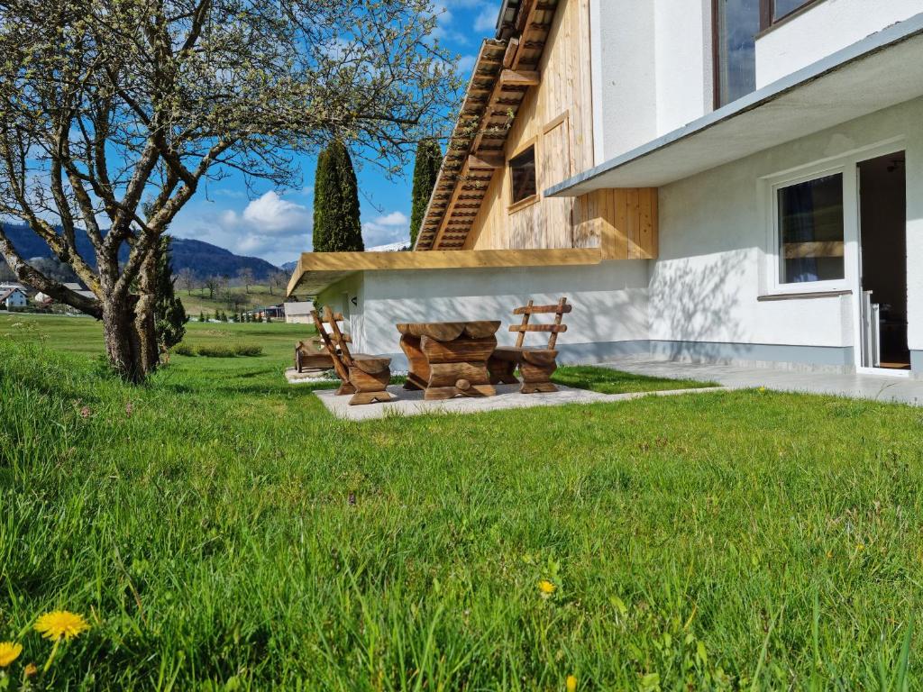 two wooden benches sitting outside of a house at M&M Apartment in Zgornje Gorje