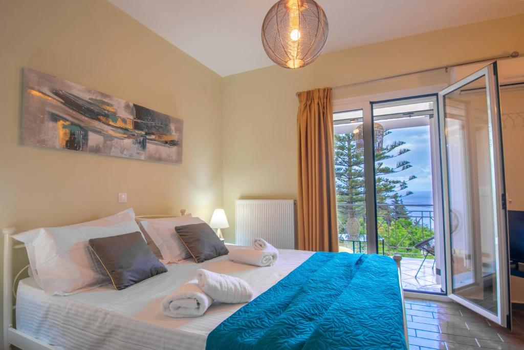 um quarto com uma cama grande e uma varanda em Alavastros Maisonettes Near 3 sandy beaches em Vasilikos