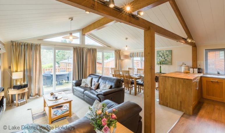 a living room with a couch and a table and a kitchen at Sheffield Pike Lodge in Windermere