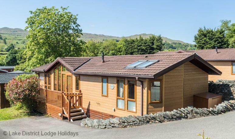 a large wooden house with a porch and a deck at Elder Lodge in Windermere