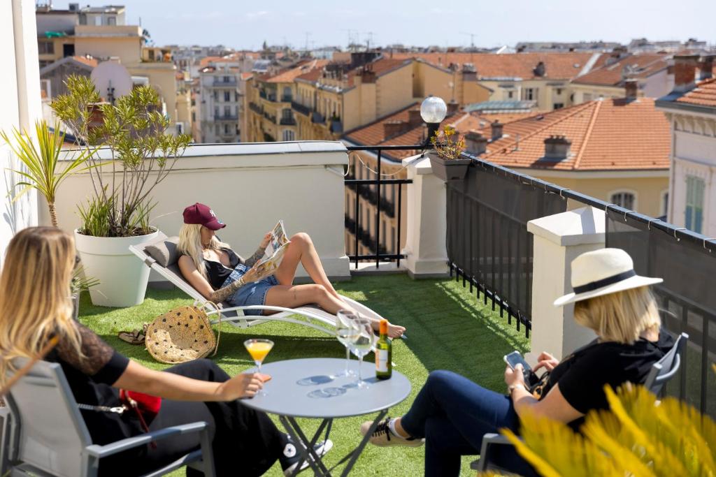 a group of women sitting on a balcony at Hôtel Byakko Nice in Nice