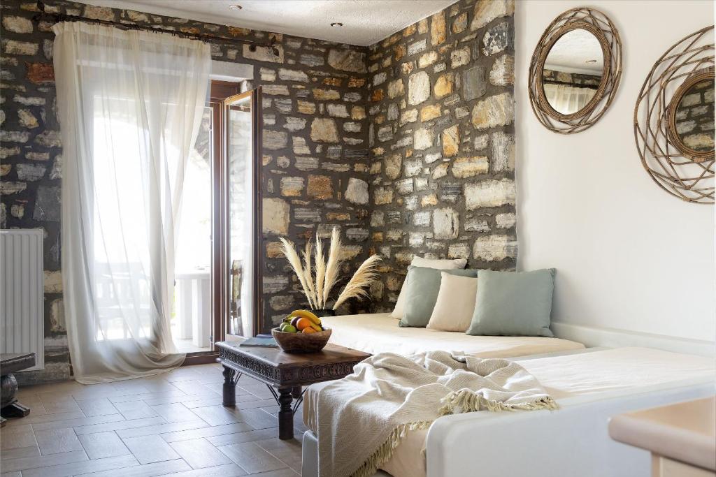 un soggiorno con divano e parete in pietra di Casa Kaly ad Agia Anna Naxos