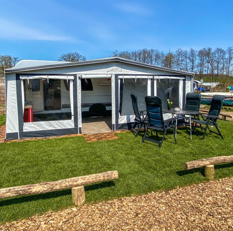 a caravan with a table and chairs in the yard at George Glamper AHOI in Belau