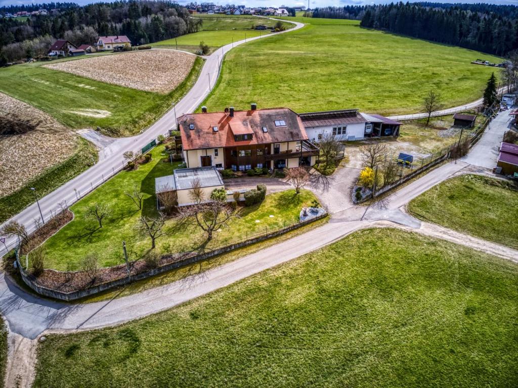 une vue aérienne sur une grande maison dans un champ dans l'établissement Ferienwohnung Amelie, à Wenzenbach