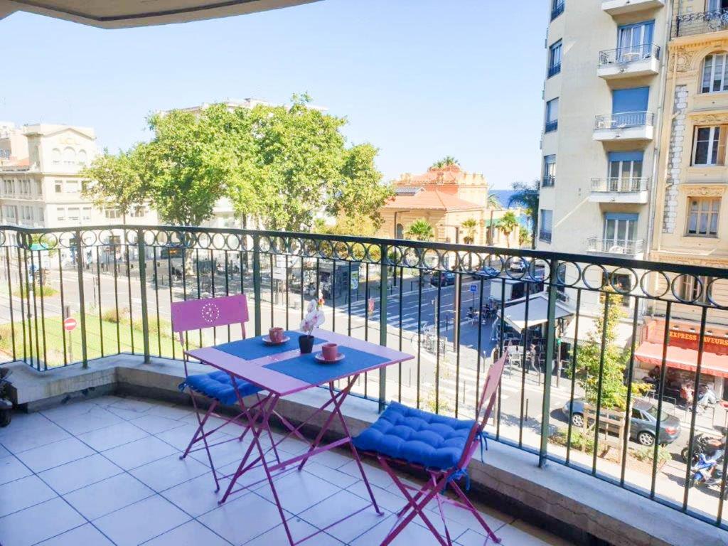 une table bleue et deux chaises sur un balcon dans l'établissement Résidence Les domes, Piscine, à Nice