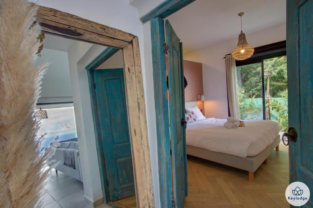 a bedroom with a bed and an open door at Villa Paloma 4 étoiles avec Piscine et Vue exceptionnelle sur l&#39;ocean à Saint-Leu in Saint-Leu