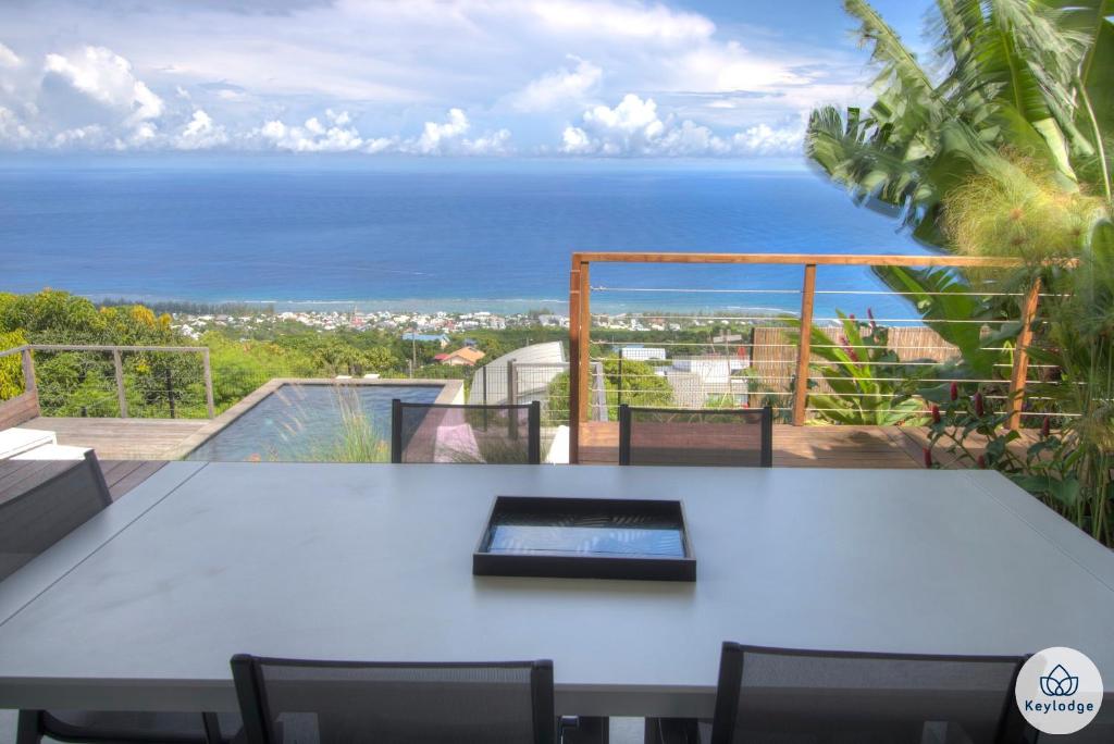 a table with chairs and a view of the ocean at Villa Paloma 4 étoiles avec Piscine et Vue exceptionnelle sur l&#39;ocean à Saint-Leu in Saint-Leu