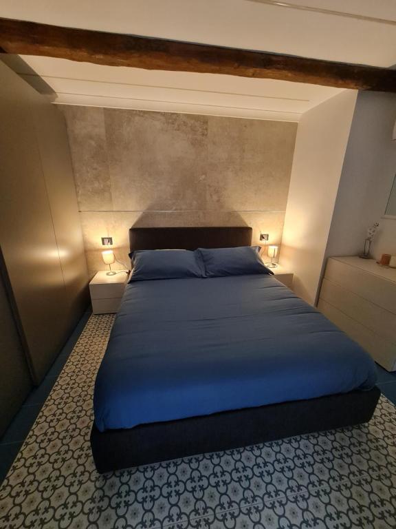 um quarto com uma cama com lençóis azuis e 2 candeeiros em Chiaja Lux House em Nápoles