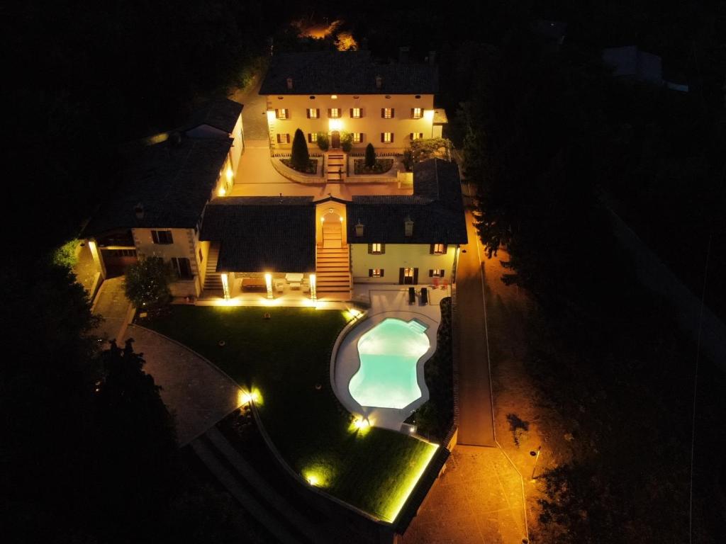 eine Luftansicht eines Hauses in der Nacht mit Pool in der Unterkunft Borgo La Morra in Pavullo nel Frignano