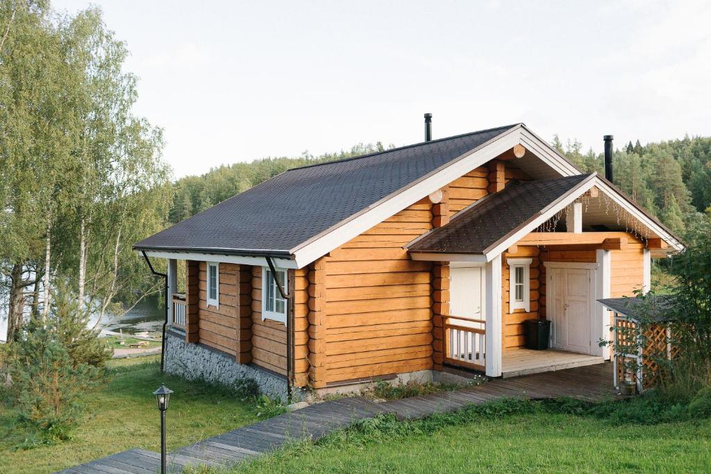 a log cabin with a porch and a door at Forrest Lodge Karelia in Reuskula