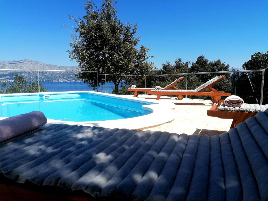 a swimming pool with a bed in front of it at Secluded Holiday home HERITAGE in Postira