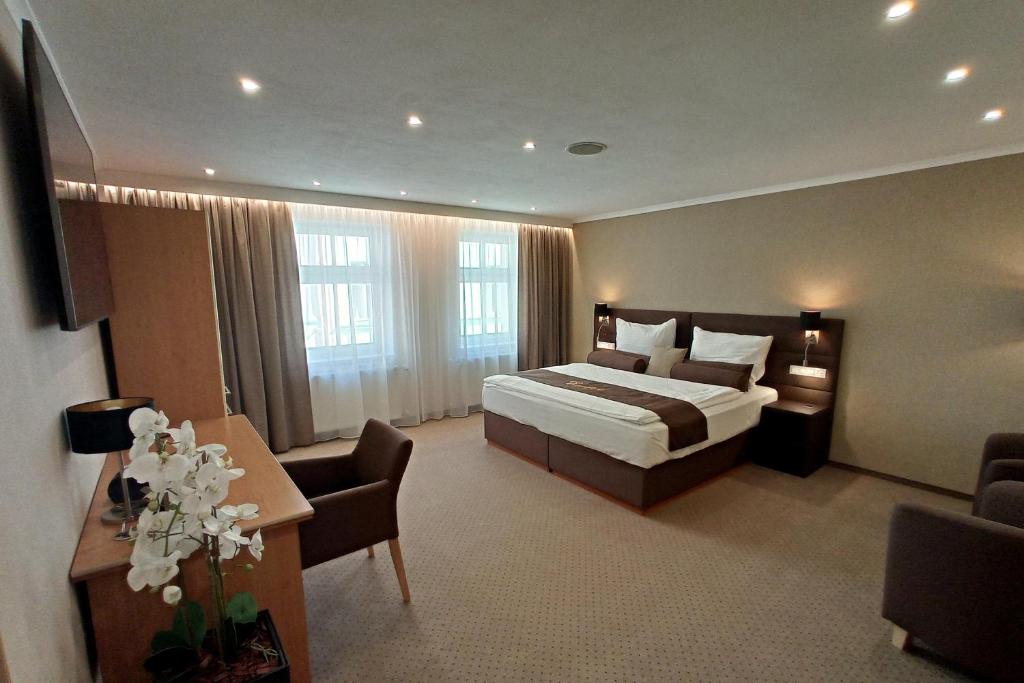 ストジーブロにあるPenzion Excellentのベッド、テーブル、椅子が備わるホテルルームです。