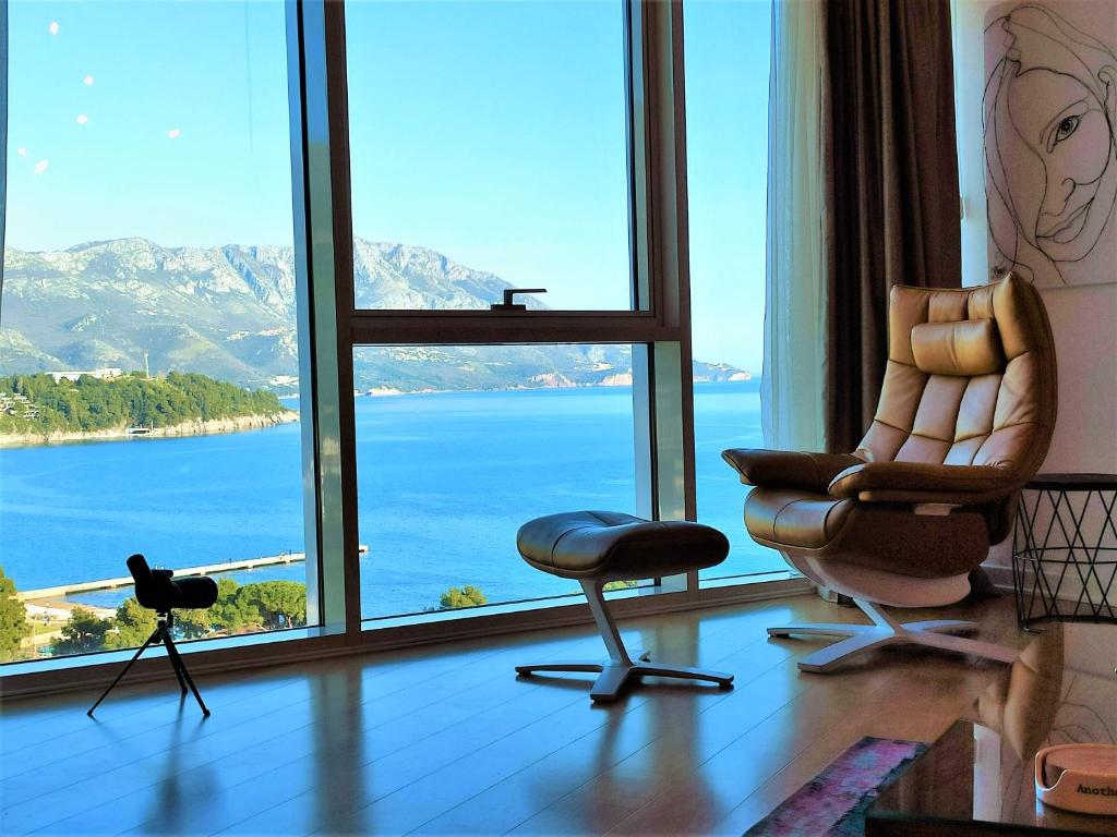 Zimmer mit einem großen Fenster mit einem Stuhl und einer Kamera in der Unterkunft Vista Deluxe Tre Canne in Budva