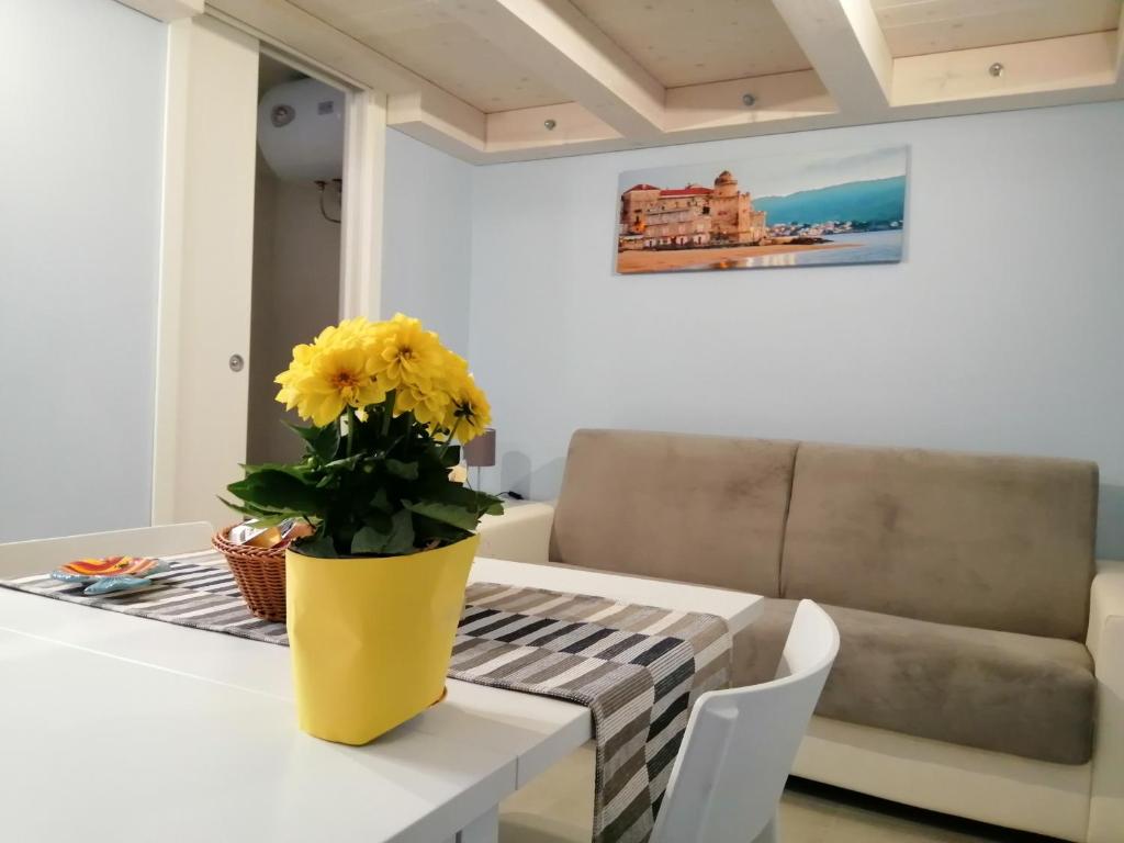 un jarrón amarillo sobre una mesa en la sala de estar en Domus Flò en Santa Maria di Castellabate