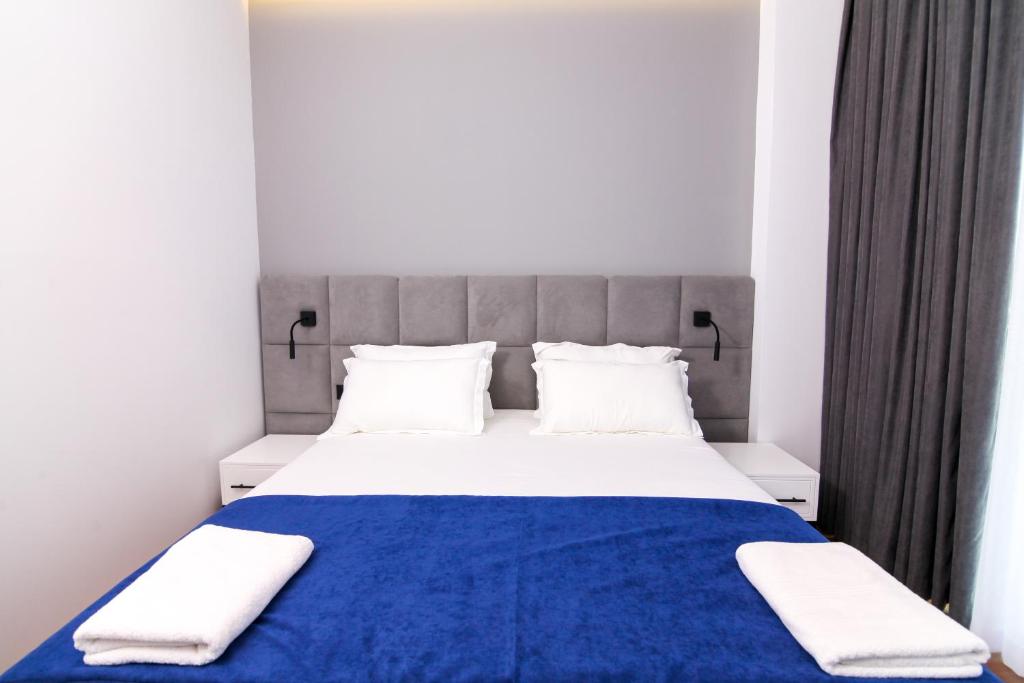 a bedroom with a blue and white bed with white pillows at N Hotel BY NOSHI in Rinas