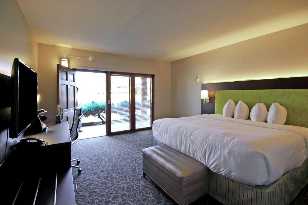 
a hotel room with two beds and a television at El Sendero Inn, Ascend Hotel Collection in Santa Fe
