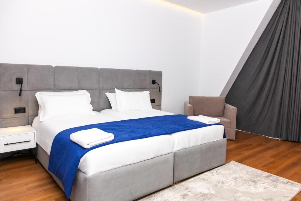 a bedroom with a large bed with a blue blanket at N Hotel BY NOSHI in Rinas
