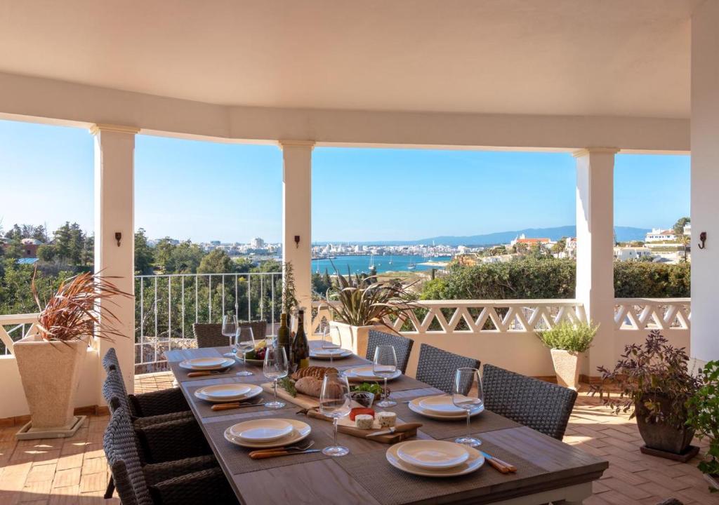 a wooden table on a balcony with a view at Villa Atlantic Blue Luxury with Ocean views in Ferragudo
