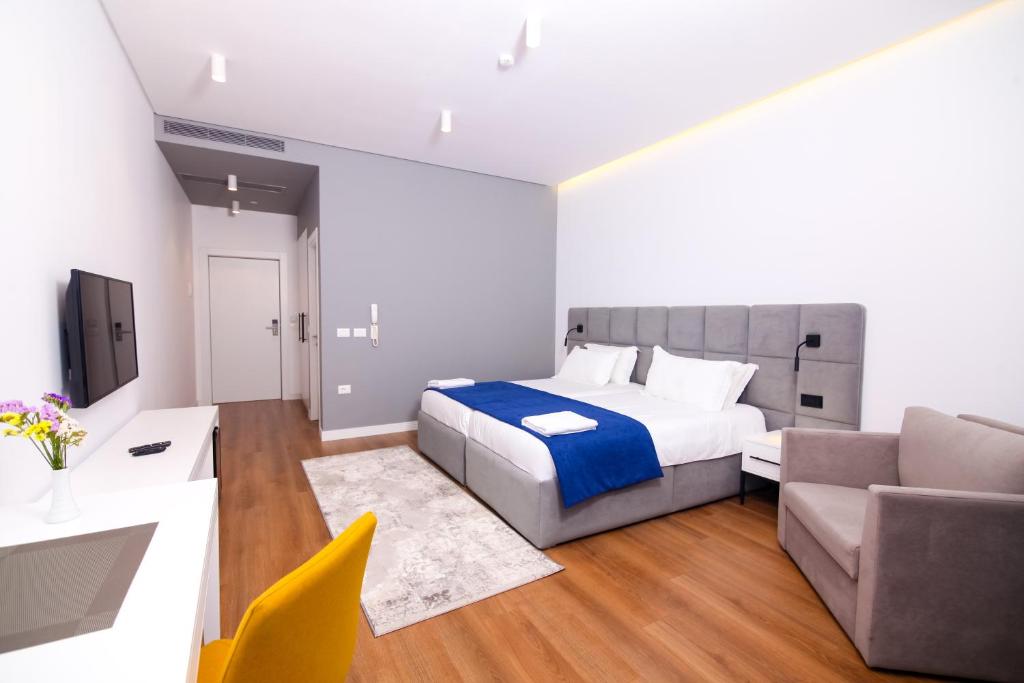 a bedroom with a bed and a couch and a television at N Hotel BY NOSHI in Rinas