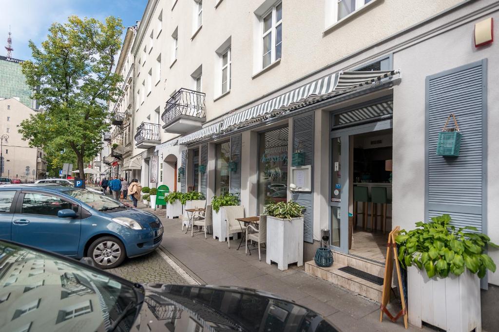 un coche azul estacionado en una calle al lado de un edificio en Plater & Poznanska Serviced Apartments, en Varsovia