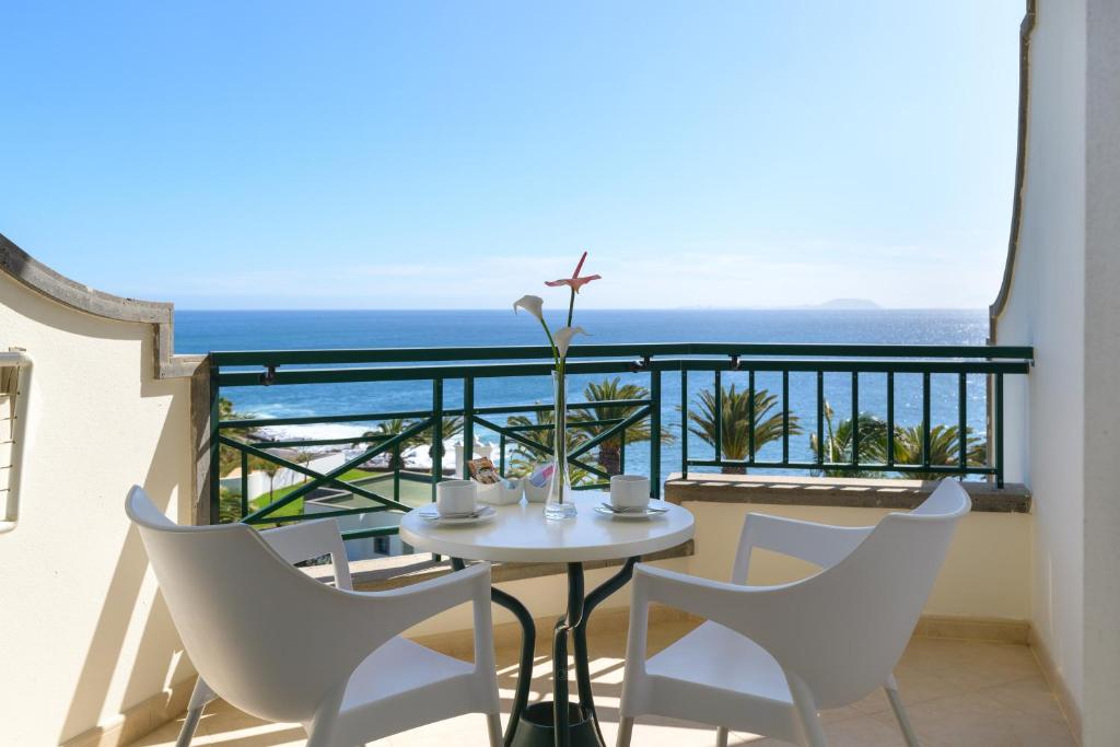 a balcony with a table and chairs and the ocean at Hipotels Natura Palace Adults Only in Playa Blanca