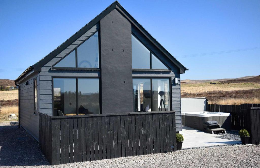 una piccola casa con finestre in vetro e vasca di Braeside Bothy a Dunvegan