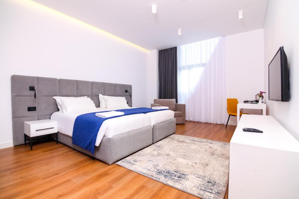 a bedroom with a large bed and a television at N Hotel BY NOSHI in Rinas