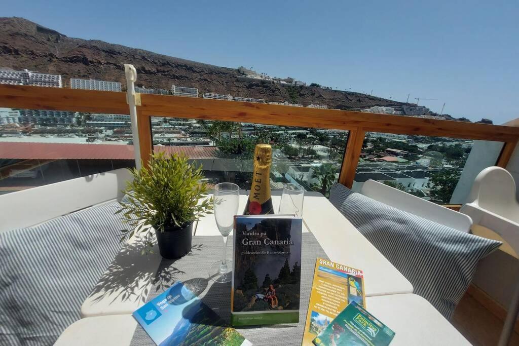 Una botella de vino en una mesa en un balcón en Arimar Seaview Puerto Rico, en Puerto Rico de Gran Canaria