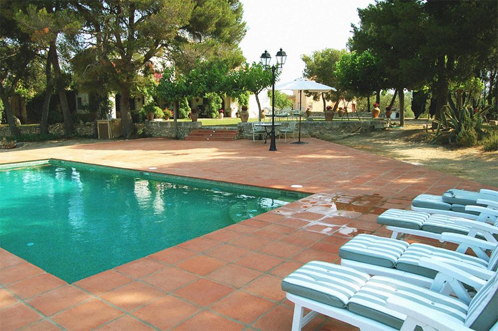 un gruppo di sedie a sdraio accanto alla piscina di MASIA BARTOMEU Rural house between vineyards 2km from the beach a El Vendrell