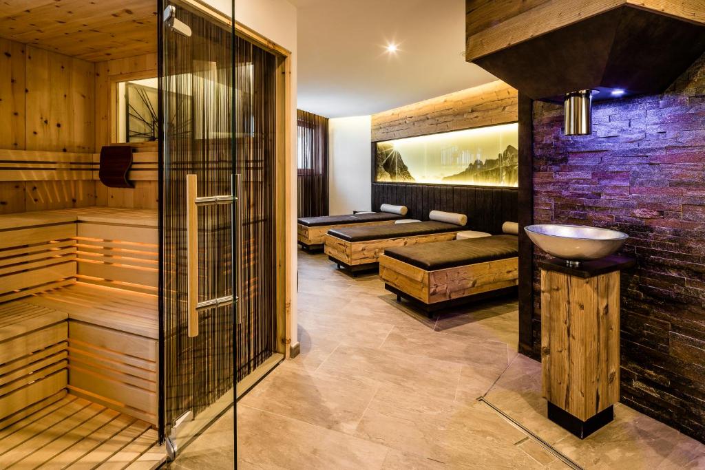 uma sauna com um lavatório e 2 camas em Apartments Hotel Garden em Selva di Val Gardena