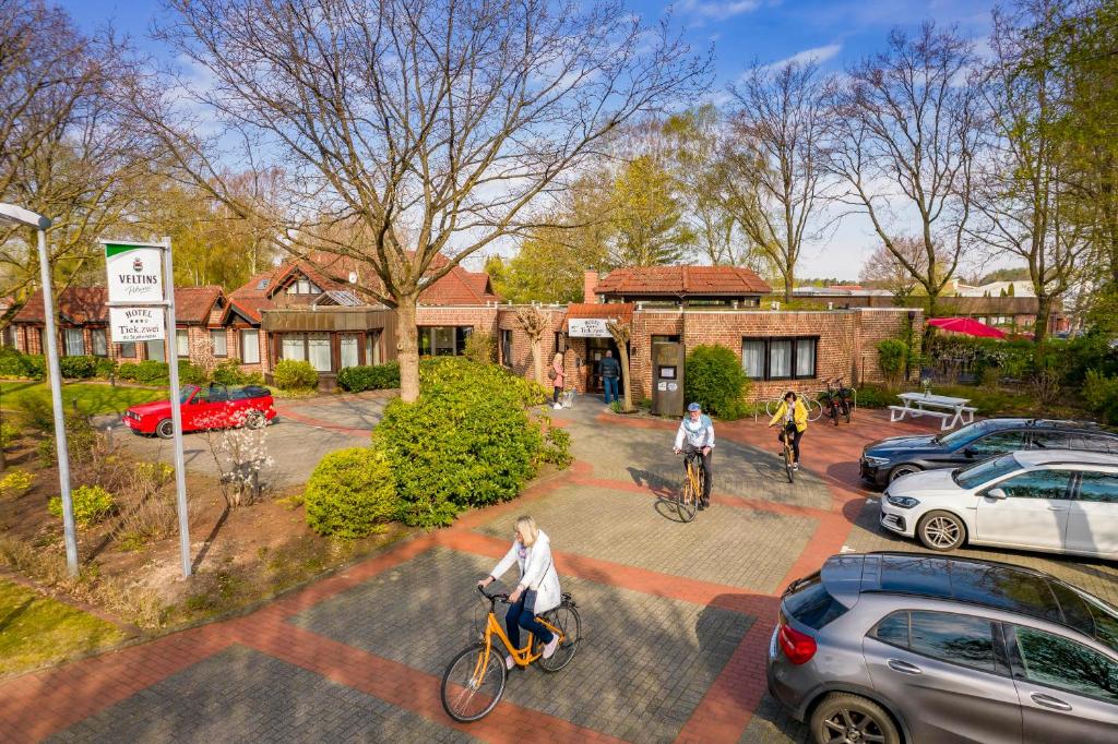a group of people riding bikes in a parking lot at Hotel TiekZwei - Ihr Studiohotel in Meppen