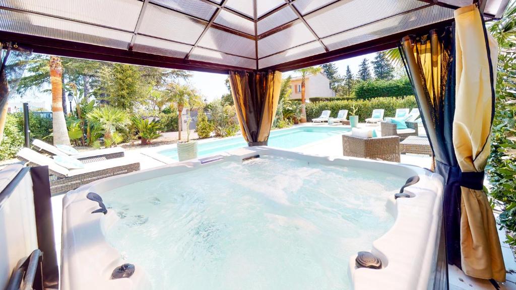 a jacuzzi tub with a view of a pool at Villa 35 de Saint Aygulf in Saint-Aygulf