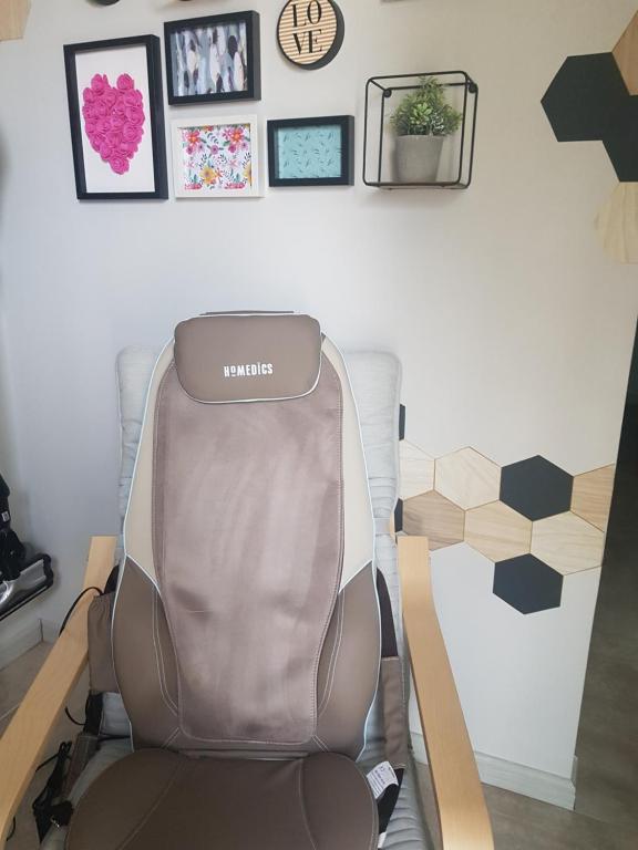 a chair in a room with pictures on the wall at gite A L' ÉVIDENCE in Mornas