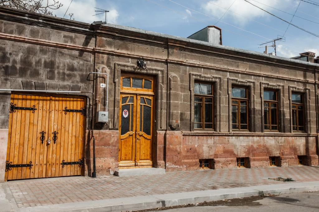 ein altes Backsteingebäude mit Holztüren und Fenstern in der Unterkunft ARmoon Hotel in Gjumri