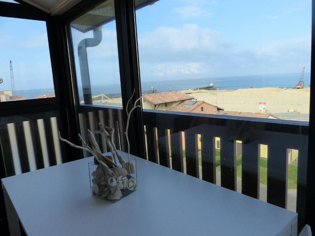 un vase assis sur une table devant une fenêtre dans l'établissement Appartement 4 Personnes Vue Sur L ocean- Residence Les Terrasses De La Dune, à Capbreton
