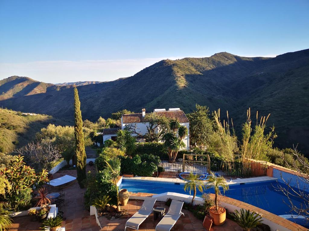 een huis met een zwembad met bergen op de achtergrond bij Apartamento Montes by Finca Los Arcos in Comares
