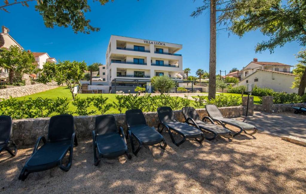 a group of chairs in front of a building at Luxury Apartments Villa Lučica in Malinska