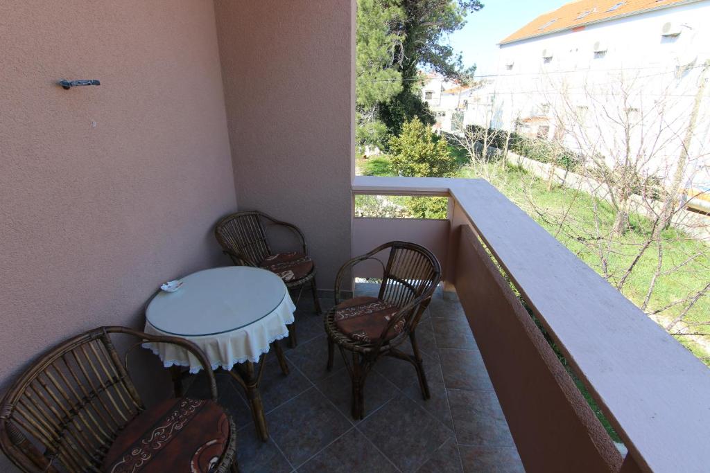 a balcony with a table and chairs and a window at Apartments Gladiola Nin in Nin