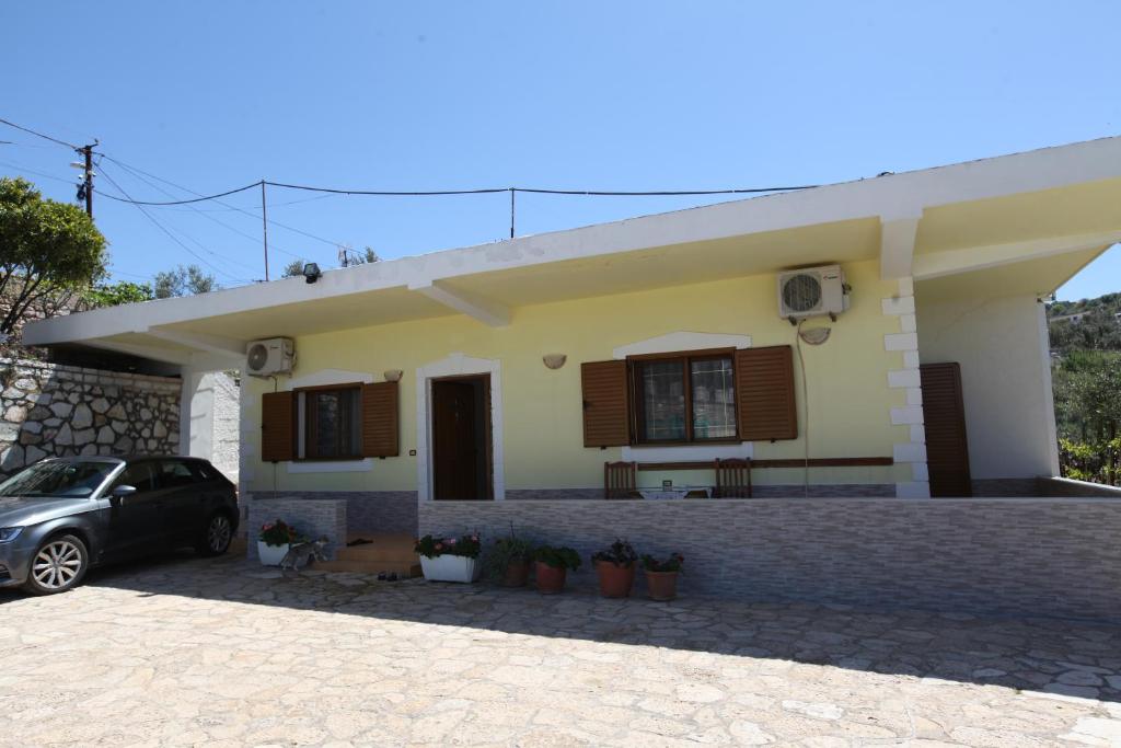 a house with a car parked in front of it at Vila Paza in Sarandë