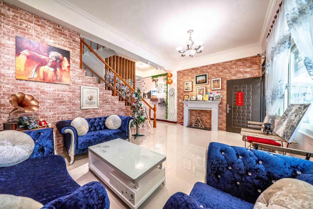 a living room with blue couches and a brick wall at Shanghai Time in Hualien City
