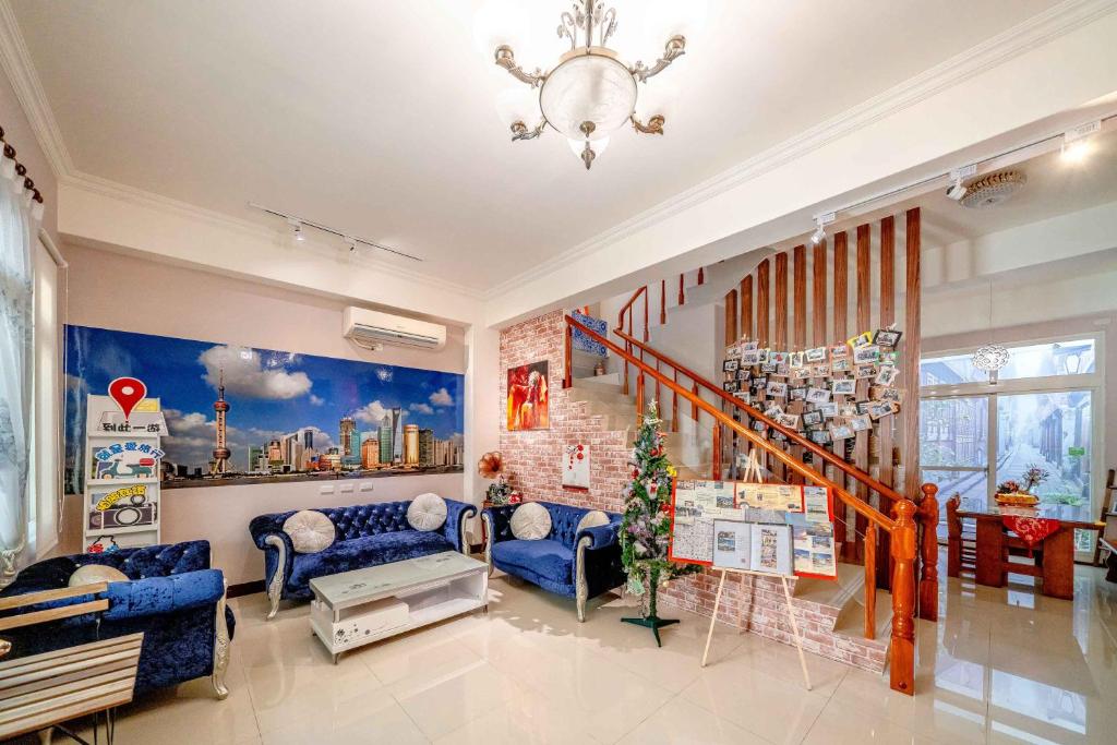 a living room with blue furniture and a staircase at Shanghai Time in Hualien City