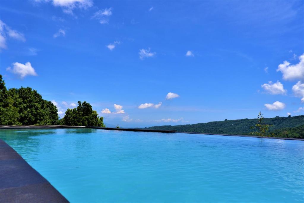 a large pool of blue water with trees in the background at Swar Bali Lodge in Munduk