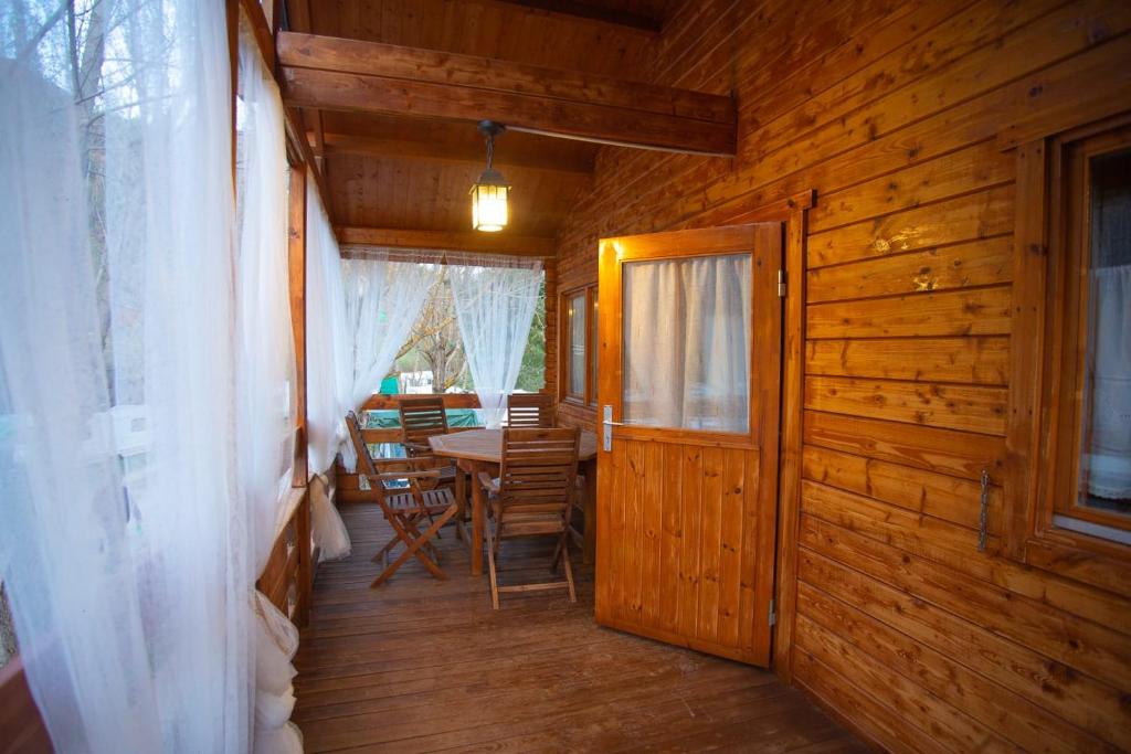 einen Flur einer Holzhütte mit einem Tisch und Stühlen in der Unterkunft Bungalow Tossa Pelada i Mobil Home Rodell in Fornols