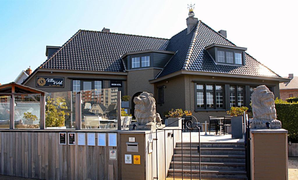 une maison avec un portail et une clôture dans l'établissement Villa Hotel (Adults only), à Middelkerke