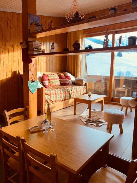 un salon avec une table et un canapé dans l'établissement Duplex VUE IMPRENABLE, 2 chb, 2 Sdb, 6 pers, à La Clusaz