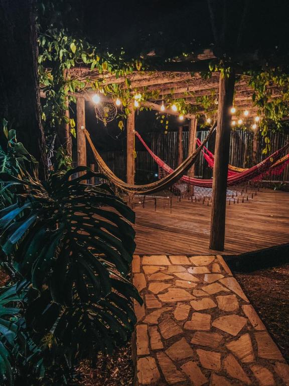a patio with a hammock and a wooden deck at night at Veredas do Cipó in Serra do Cipo